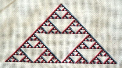 Ted Ashton's colored Sierpinski variant, cross-stitched.  No, the photo is not blurry.  That's the way the colors are arranged.